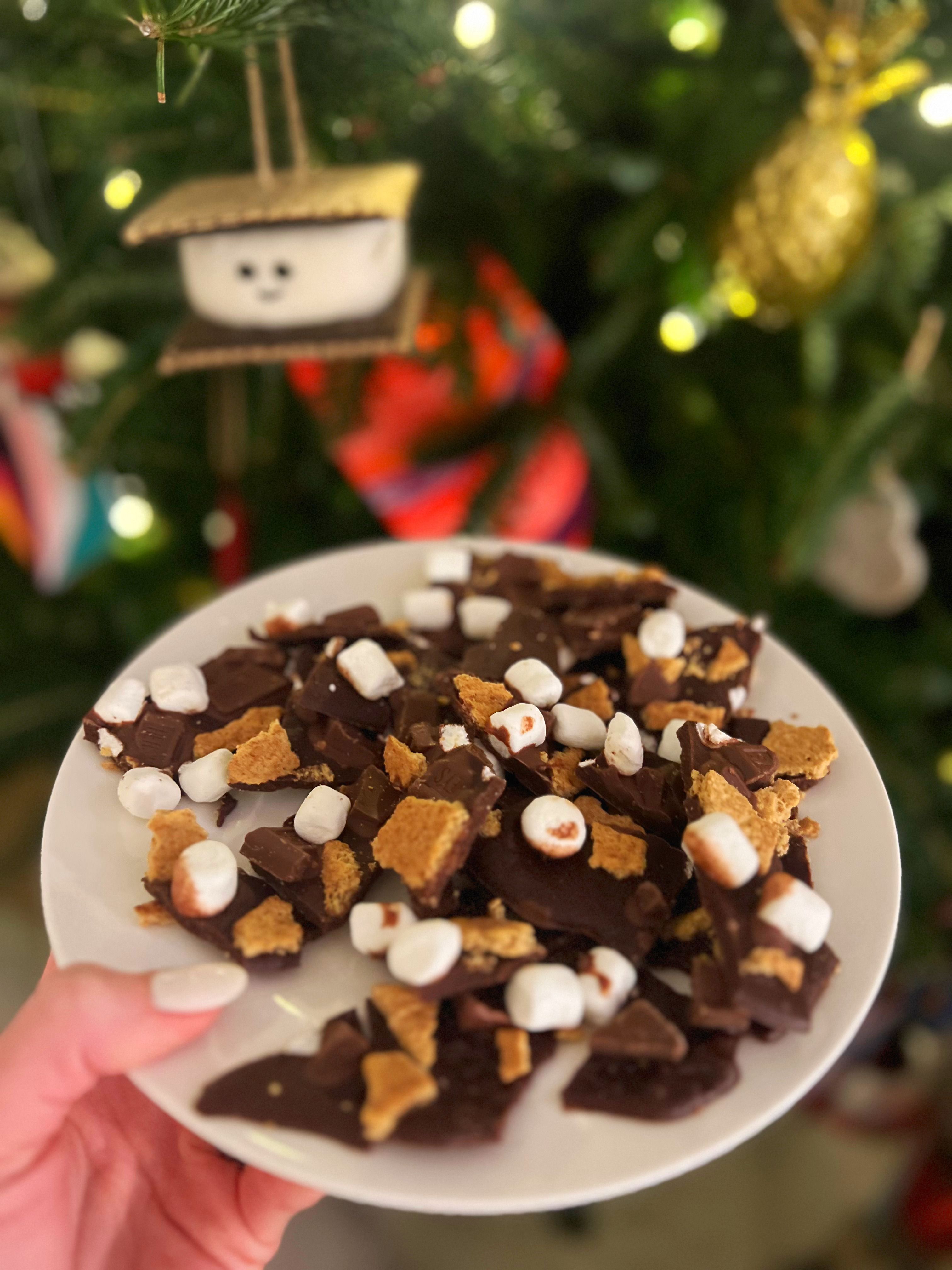 A plate of custom made chocolate bark in front of a Christmas tree